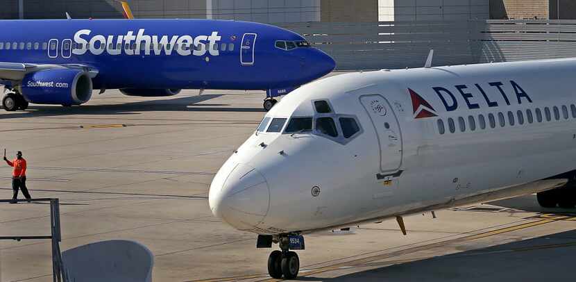 Delta Air Lines flight 1279 from Atlanta pulls into the gate 15 past a Southwest Airlines...