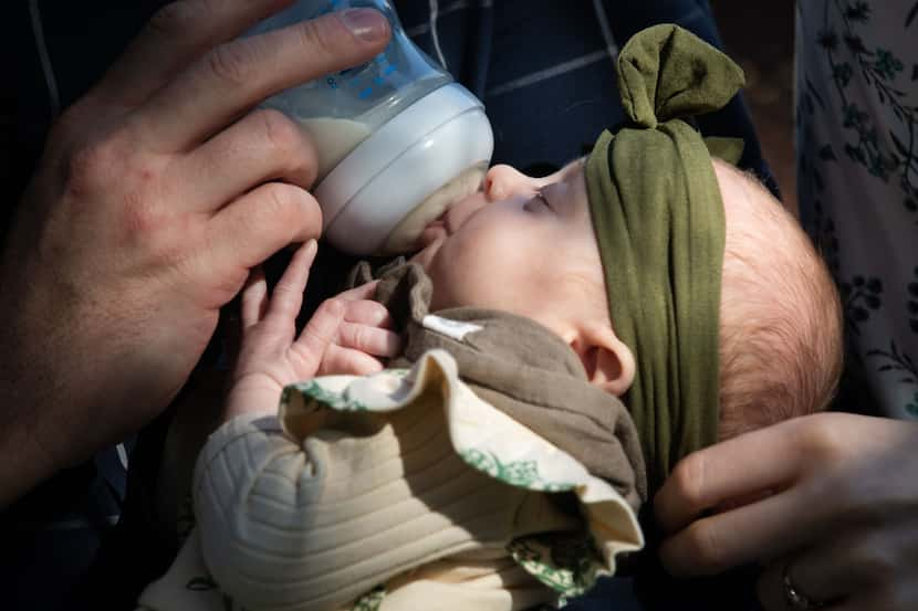 Two-month-old Lydia Danielle Clark eats while being held by her parents, Marianne Wood-Clark...