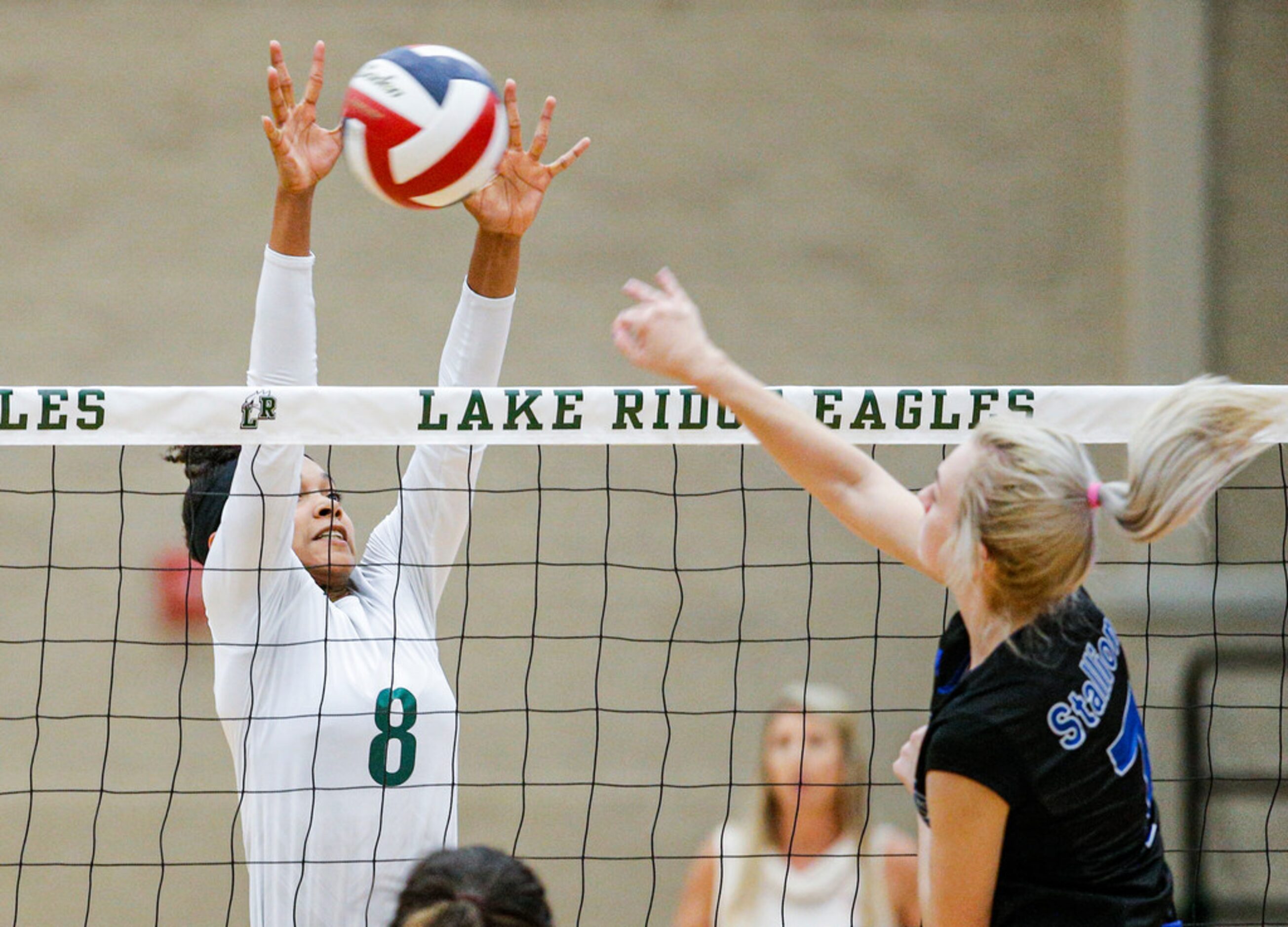 Mansfield Lake Ridge junior Lyric Stewart (8) attempts to block a spike by North Mesquite...