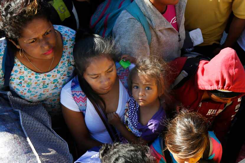 Migrants traveling with a caravan hoping to reach the U.S. border, wait to board a bus in La...