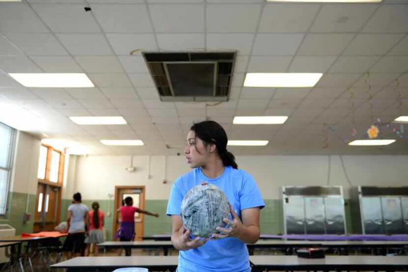 
Cecilia Garza, 17, holds a papier-mâché balloon made by children at Boys & Girls Club of...