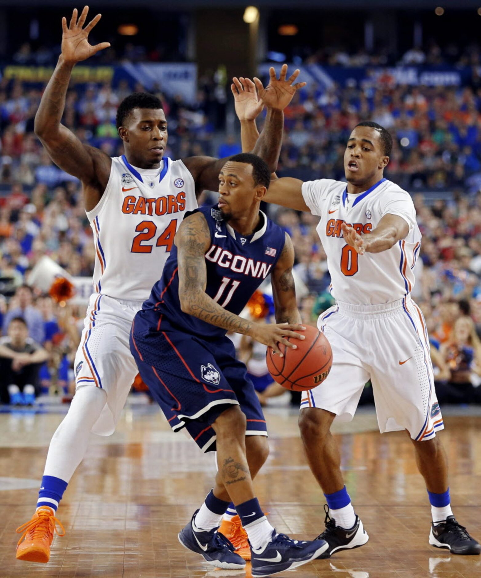 Florida Gators forward Casey Prather (24) and guard Kasey Hill defend Connecticut Huskies...