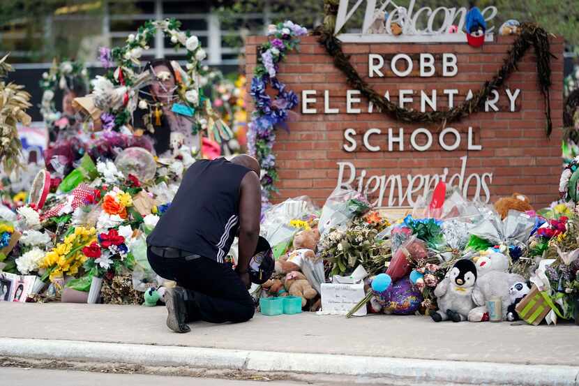 FILE - Reggie Daniels pays his respects a memorial at Robb Elementary School, June 9, 2022,...