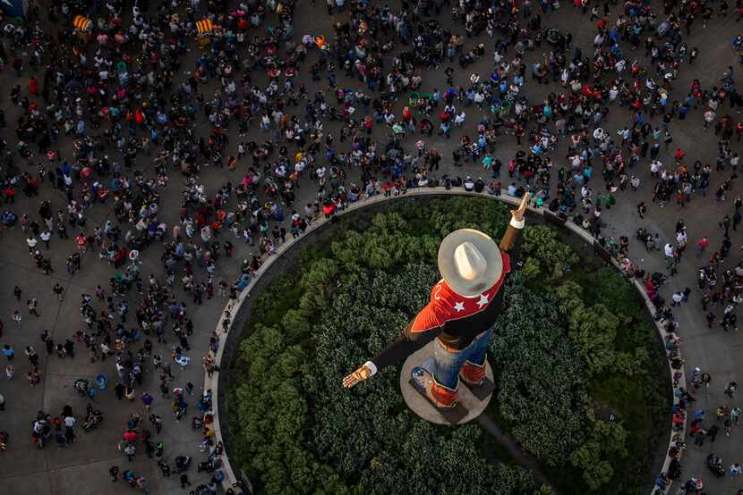 The last rays of sunlight fall over Big Tex as crowds fill the State Fair of Texas in Fair...