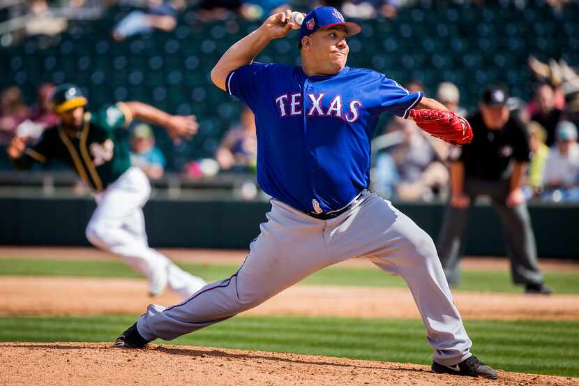 Texas Rangers pitcher Bartolo Colon pitches during the third inning of a spring training...