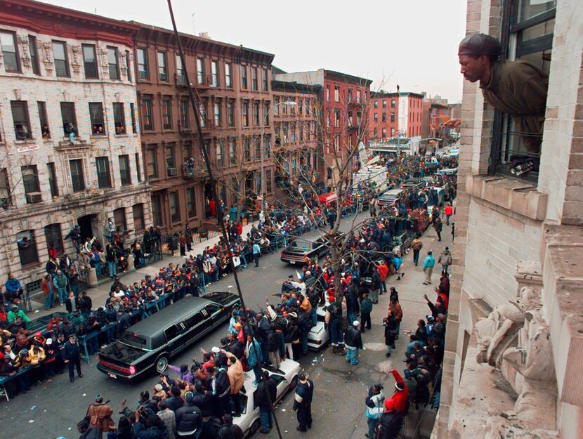 In this March 18, 1997, file photo, a man looks out his apartment window at the funeral...