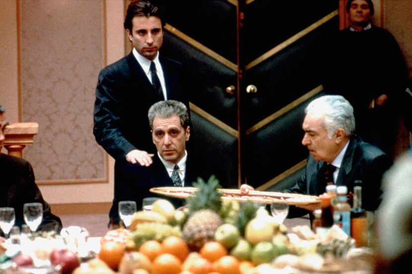 Andy Garcia (de pie) y Al Pacino en el set de la película The Godfather: Part III, escrita y...