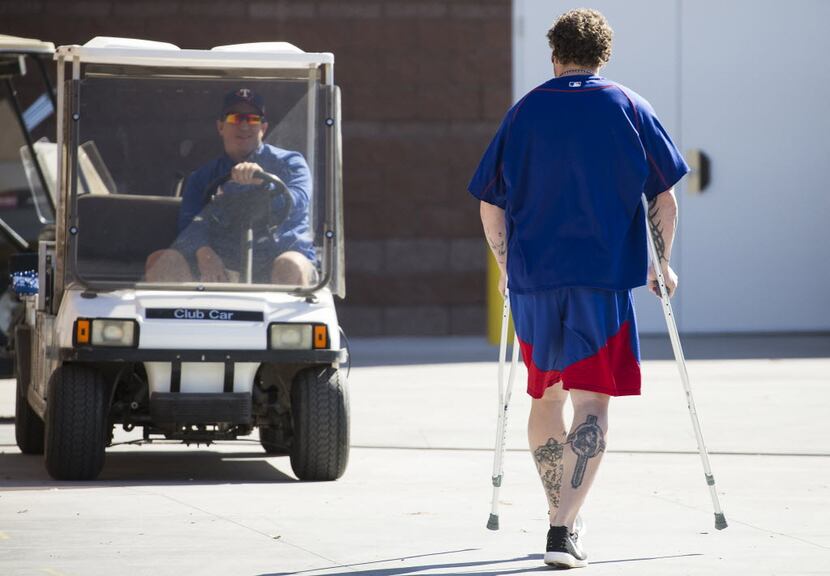 Texas Rangers outfielder Josh Hamilton uses crutches as he heads for the clubhouse after...