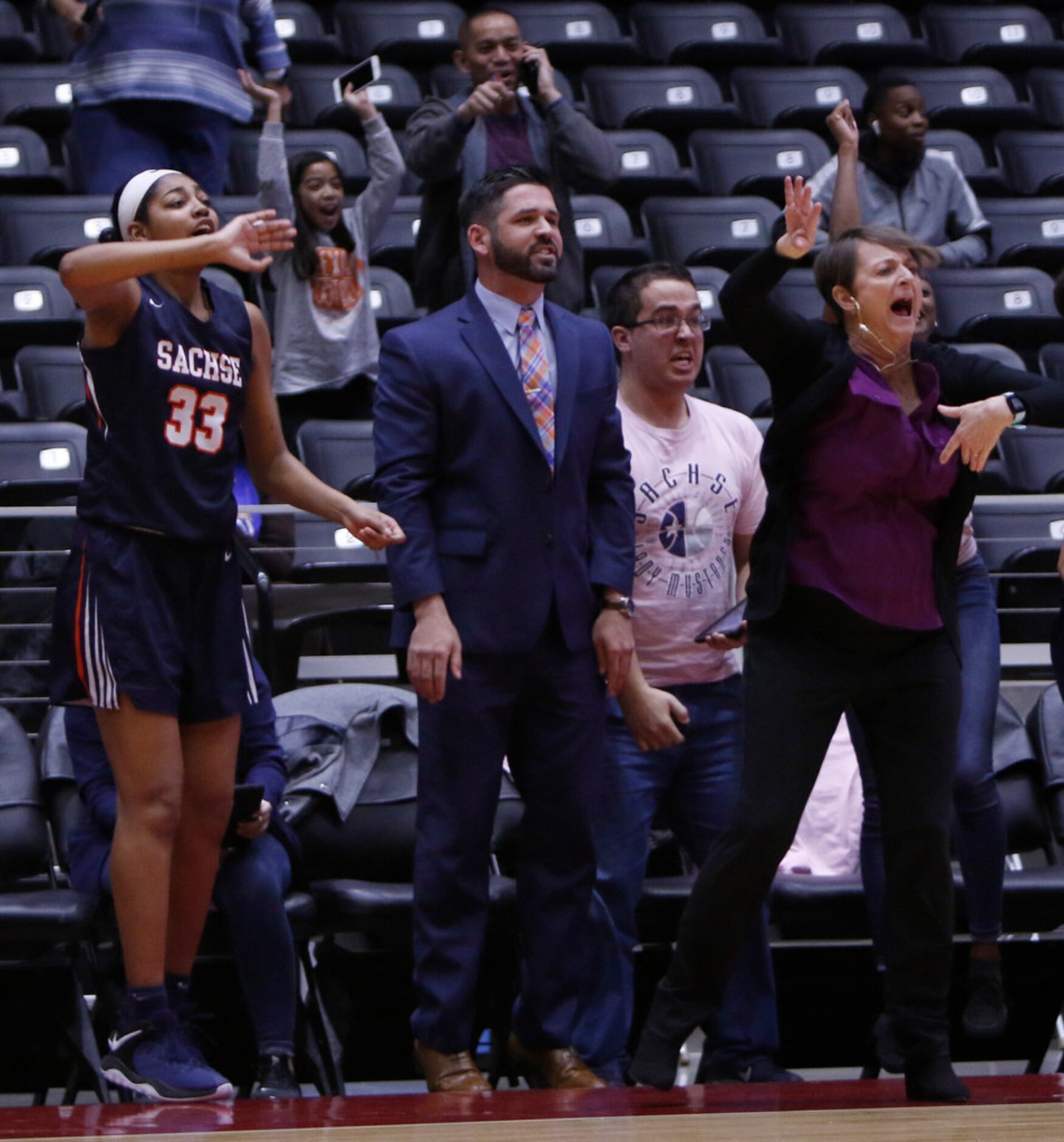 Sachse head coach (as well as her necklace) react from the team bench area following a...