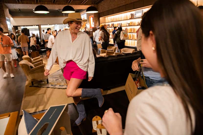 Carrie Case tries on blue suede boots during the opening of the new Tecovas store located at...