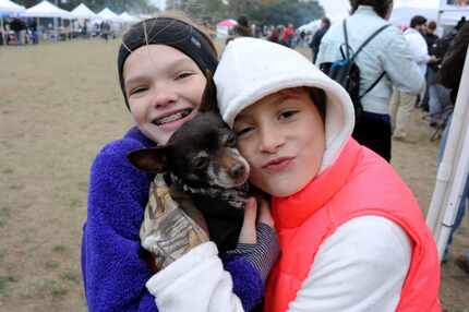 Friends Chloe Johnson and Vivienne Bull snuggled their puppy, Meaty, to keep him warm at a...