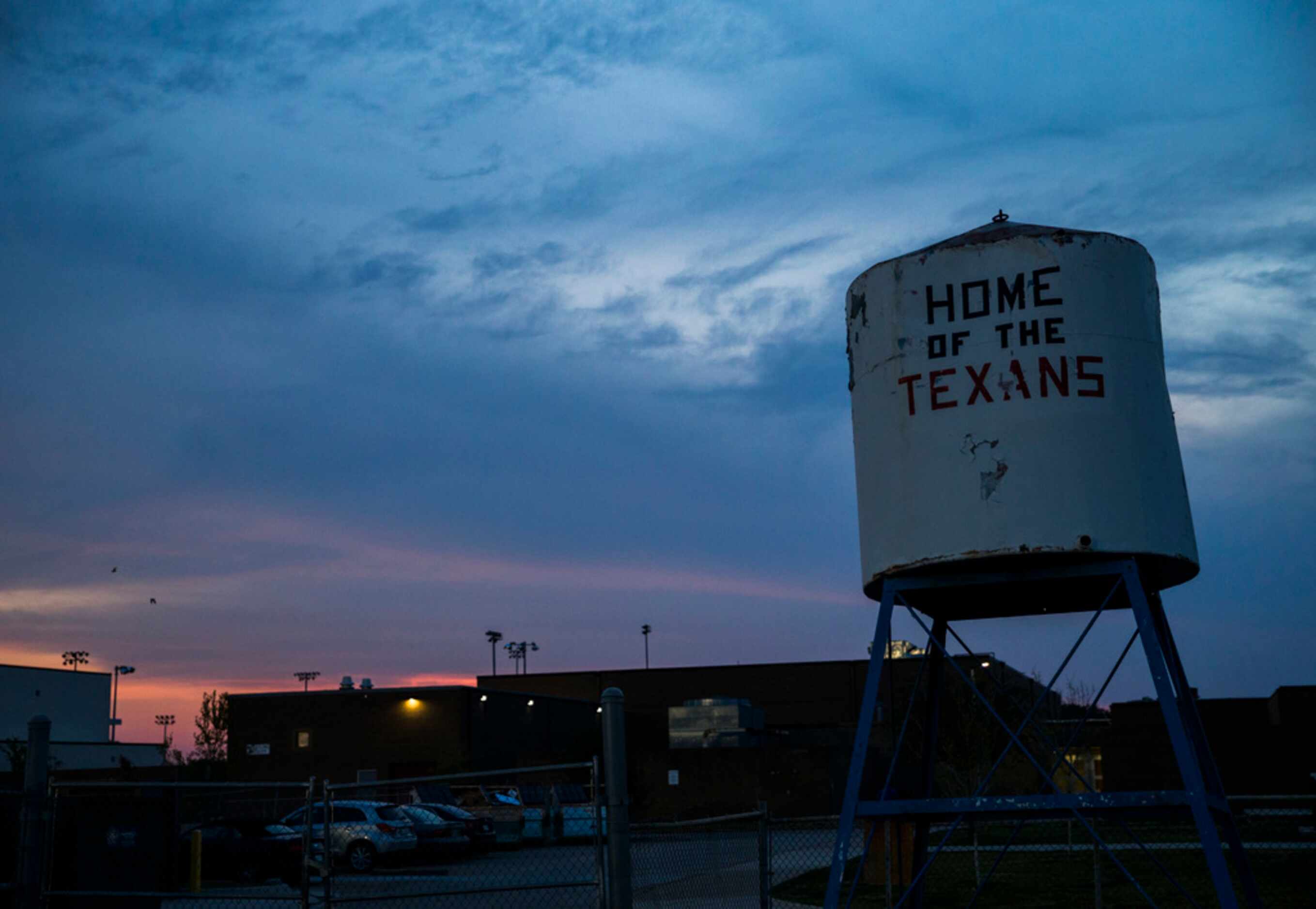 The sun sets behind the stadium at half time of a high school football game between Flower...