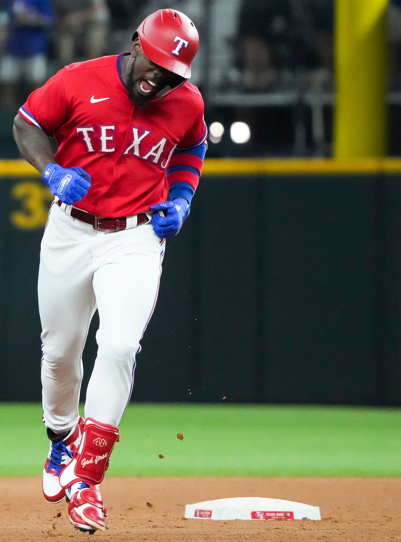 Texas Rangers center fielder Adolis Garcia celebrates as he rounds the bases after hitting a...