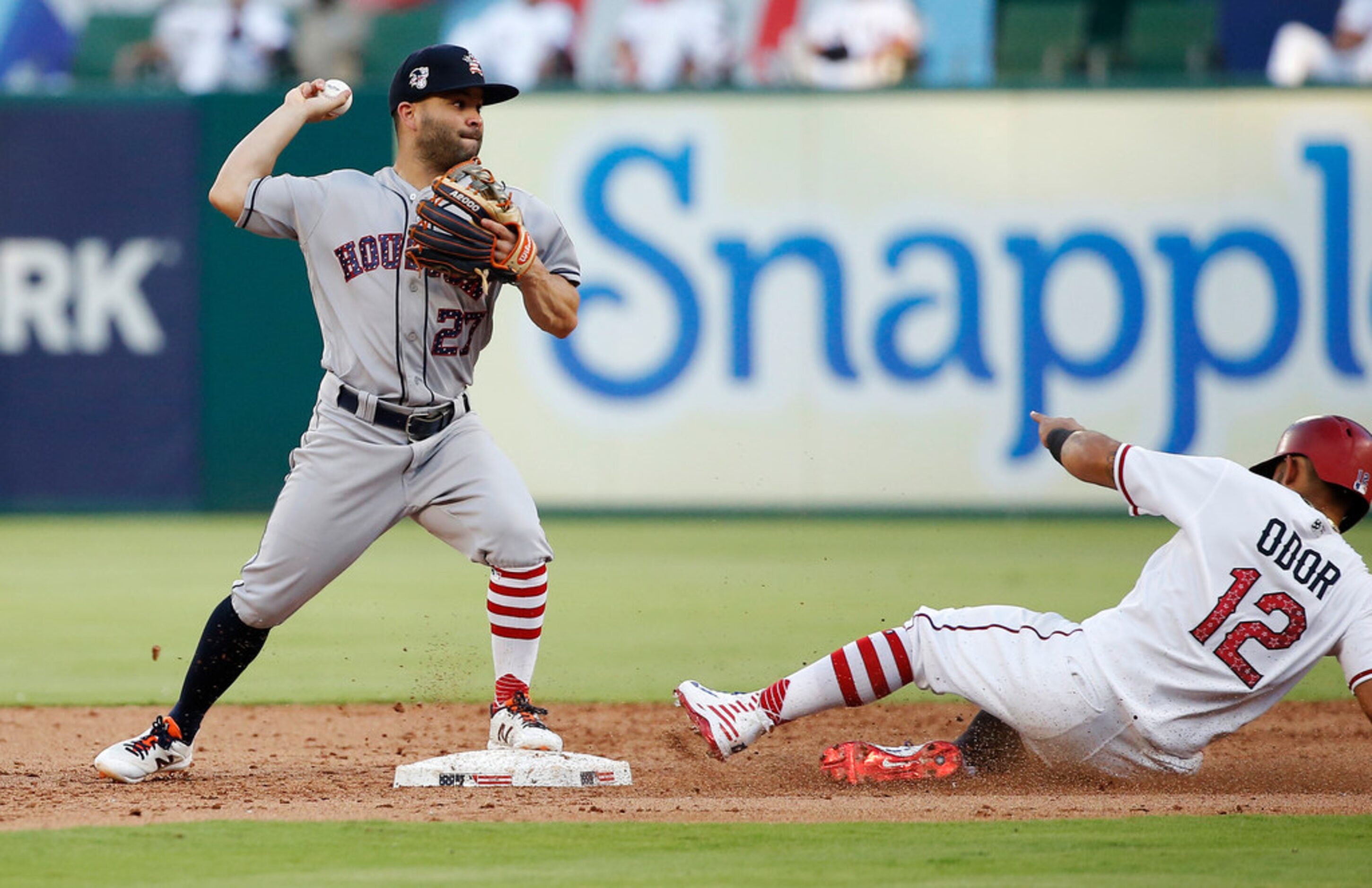 Houston Astros second baseman Jose Altuve (27) throws to first to turn a double play after...