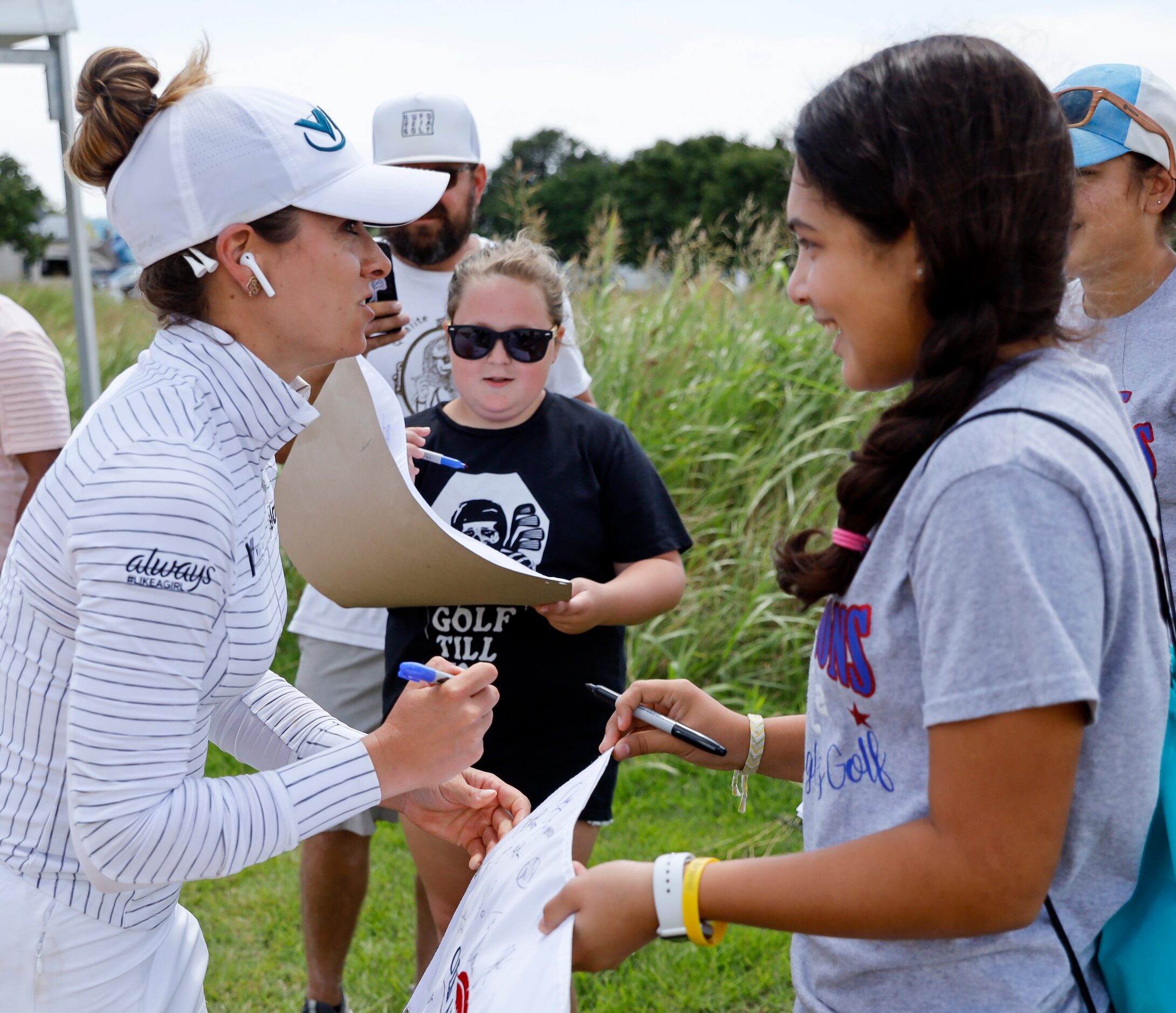 Professional golfer Gaby Lopez signs a pin flag for Kieli Saenz, 15, of Corpus Christi prior...