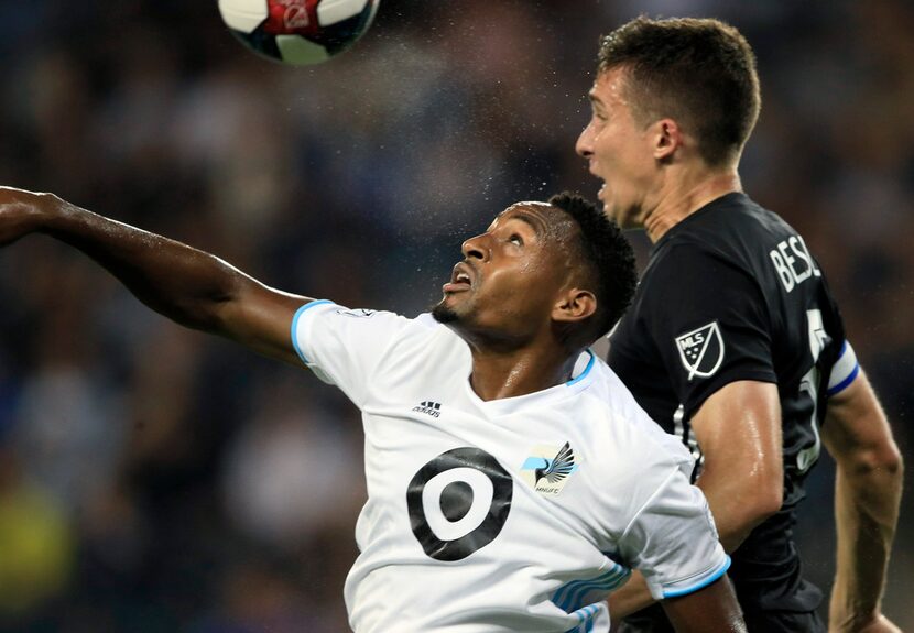 Minnesota United forward Mason Toye, left, heads the ball next to Sporting Kansas City...