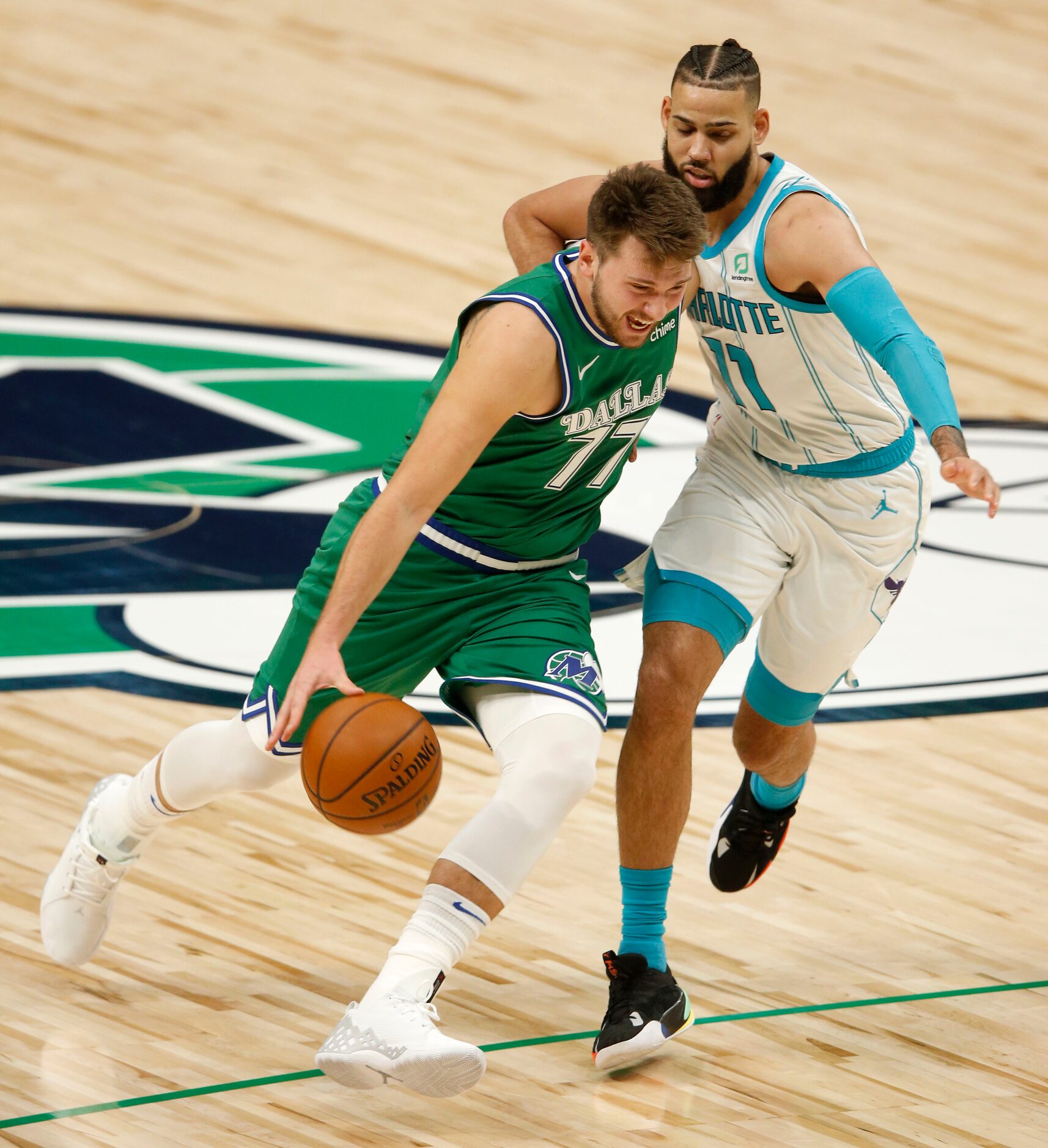 Dallas Mavericks guard Luka Doncic (77) drives up the court as he is defended by Charlotte...