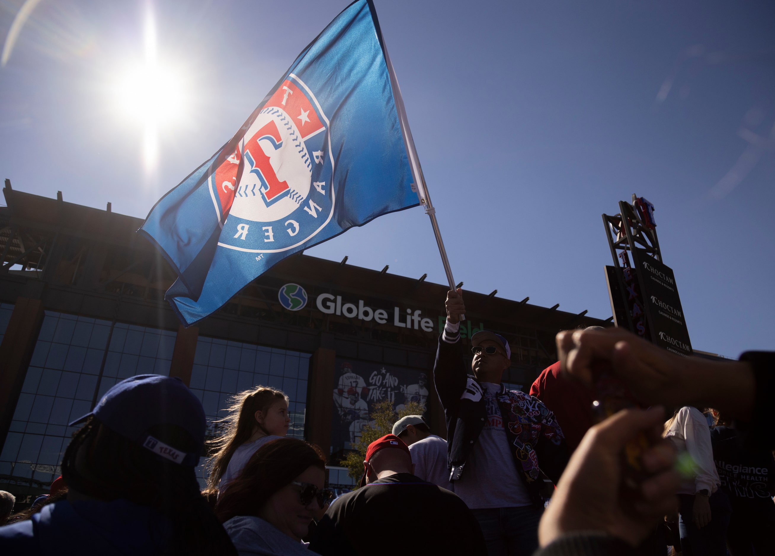 A fan waves a Texas Rangers flag outside of Globe Life Field in Arlington before the Texas...