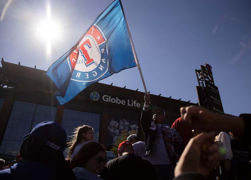 Un aficionado ondea una bandera de los Texas Rangers afuera del Globe Life Field en...