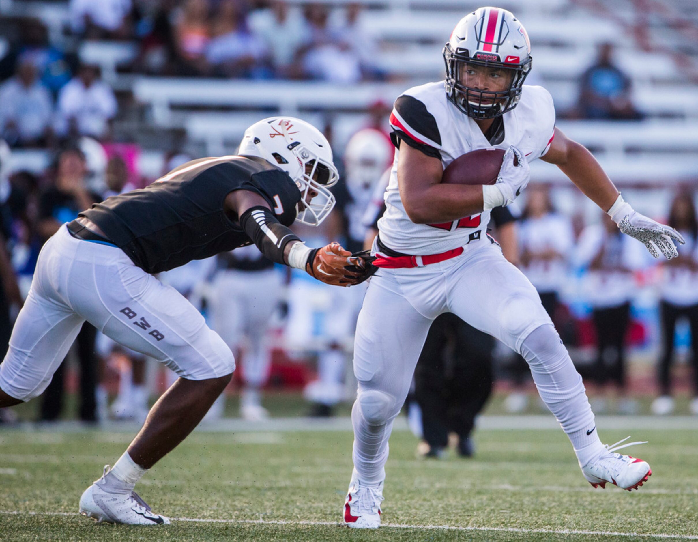 Flower Mound Marcus running back Ty'son Edwards (22) escapes a tackle attempt by Arlington...