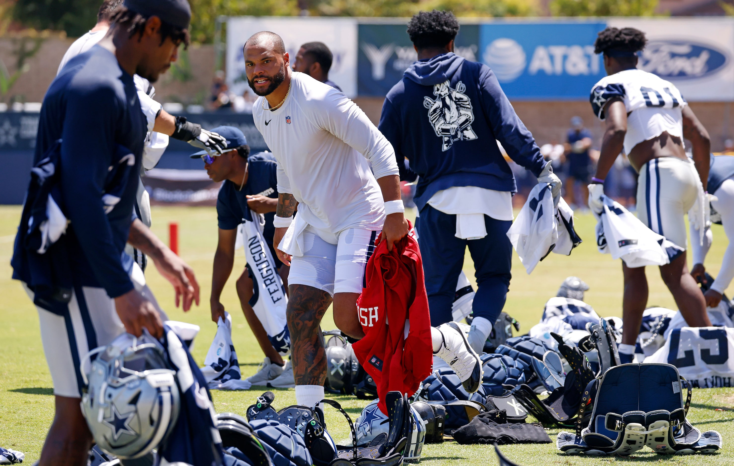 Dallas Cowboys quarterback Dak Prescott (4) and other players scramble to unearth their...