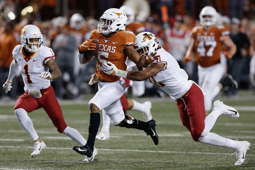 AUSTIN, TX - NOVEMBER 17:  Tre Watson #5 of the Texas Longhorns rushes the ball defended by...