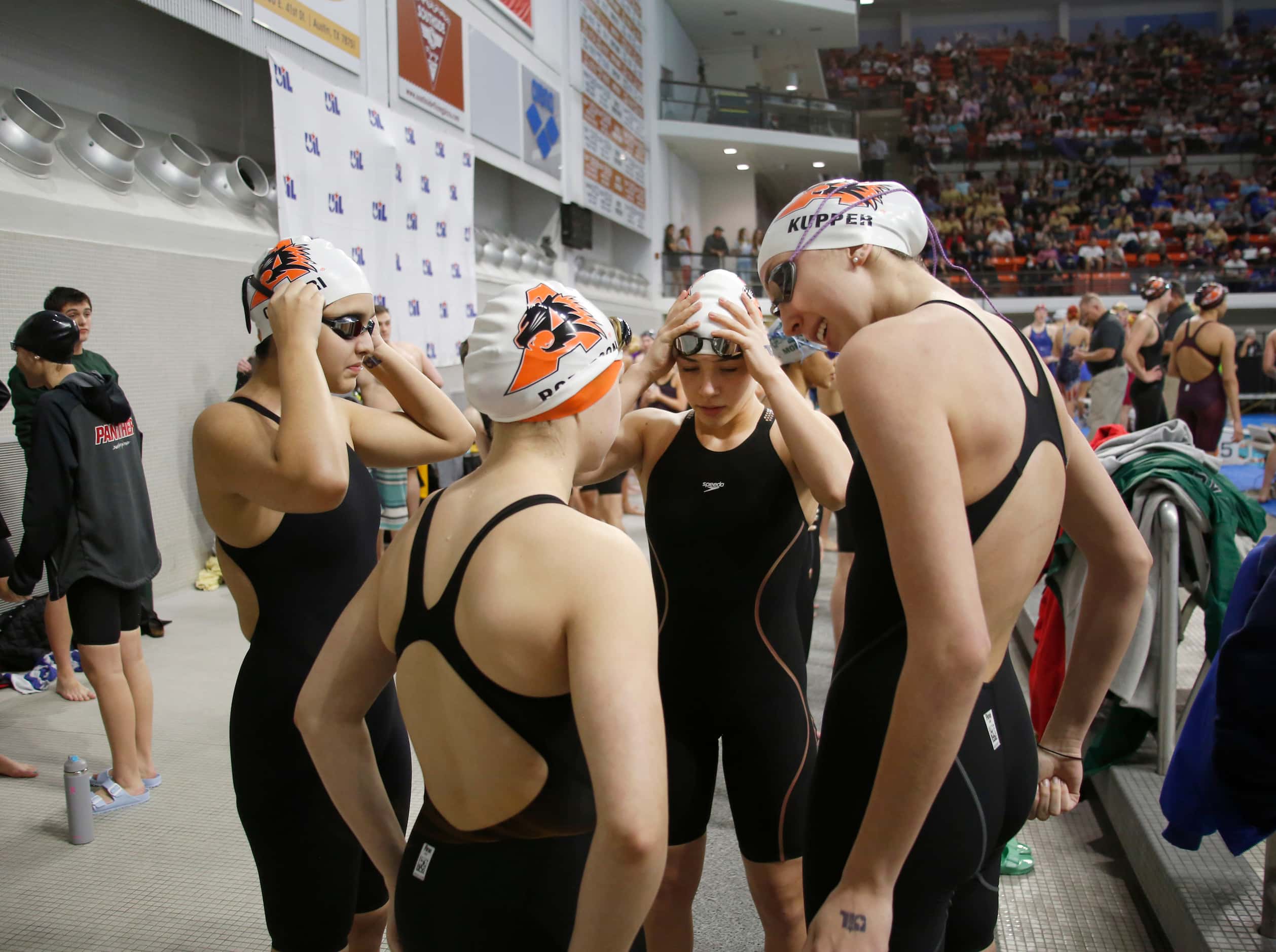 Members of Aledo's Girls 200 yard freestyle relay team converse before the start of their...