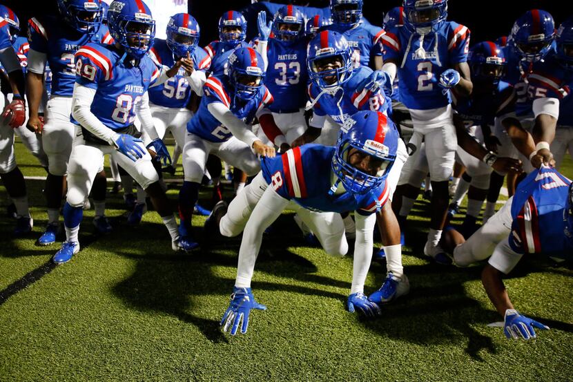 Duncanville players make their entrance by pretending to be a pack of dogs before a game...