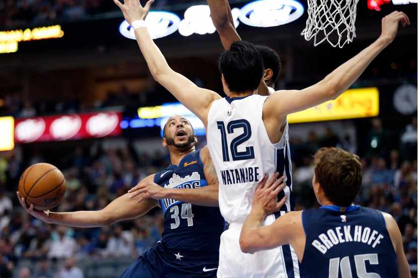 Dallas Mavericks guard Devin Harris (34) tosses up a running shot as he crosses the lane...