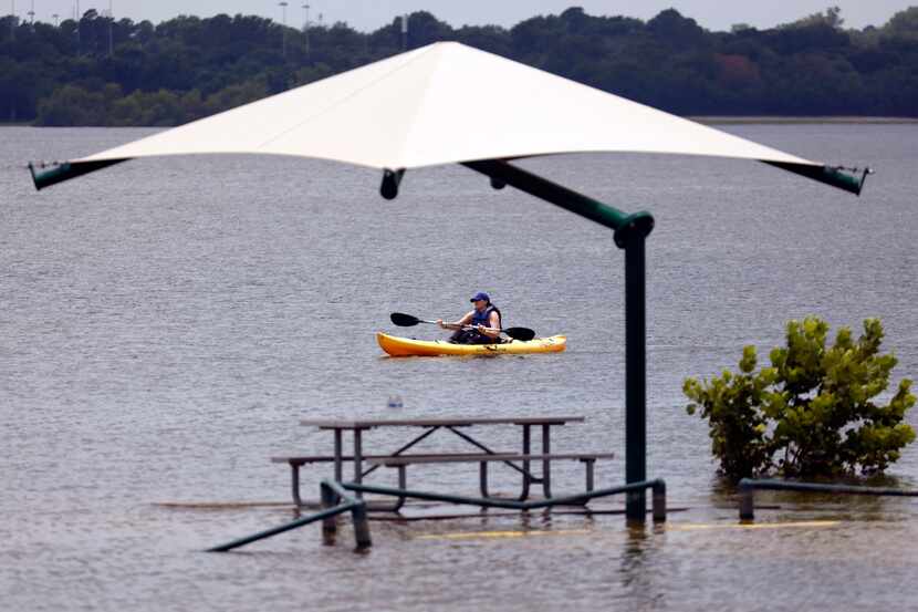 Tab Bosse of Euless paddles a kayak around Grapevine Lake near Rockledge Park, June 20,...
