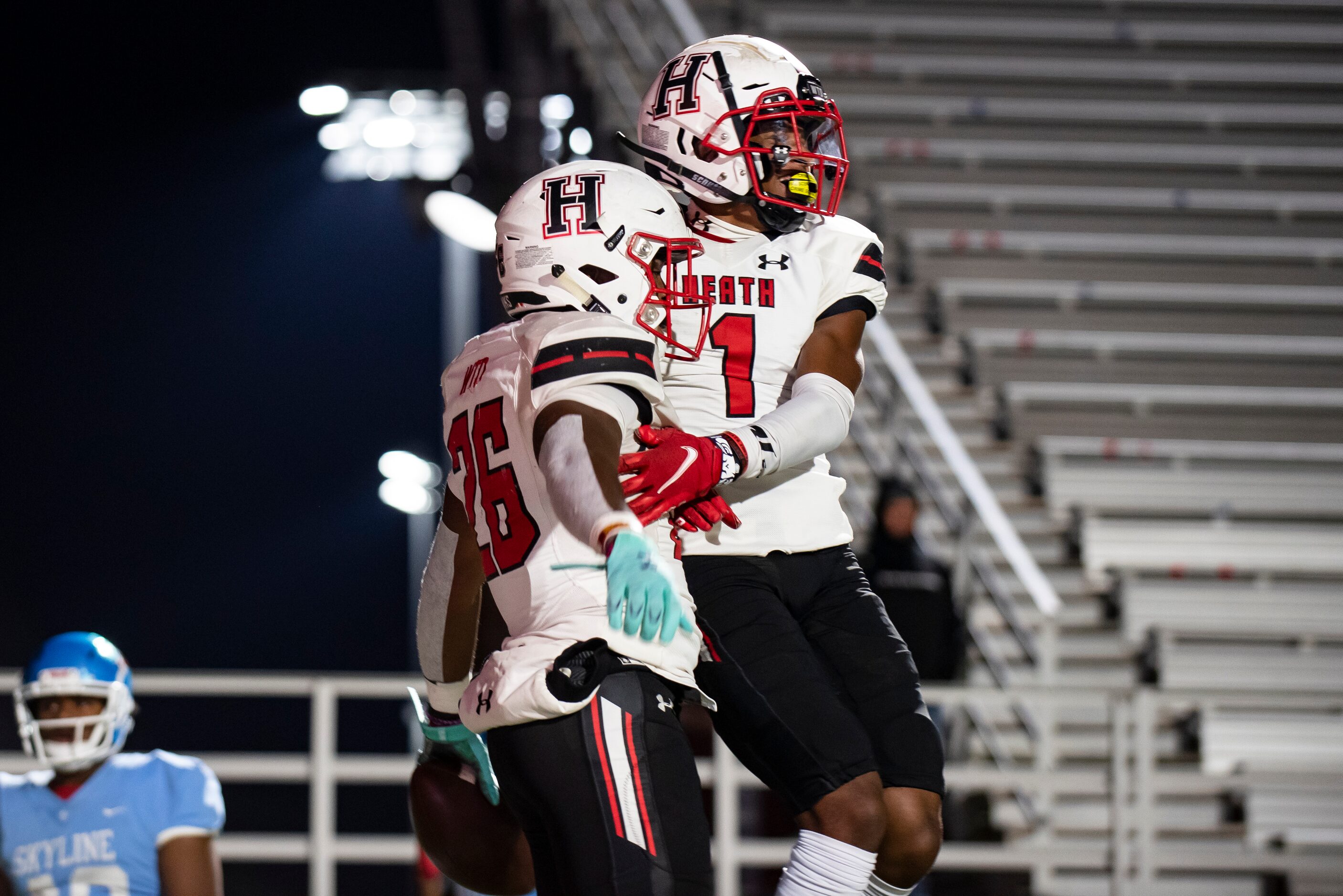 Heath senior Zach Evans (26) celebrates with Heath senior Jay Fair (1) after scoring a...