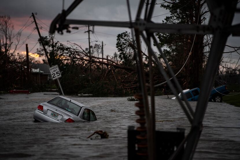 A car is caught in flood water in Panama City, Fla., after Hurricane Michael made landfall...