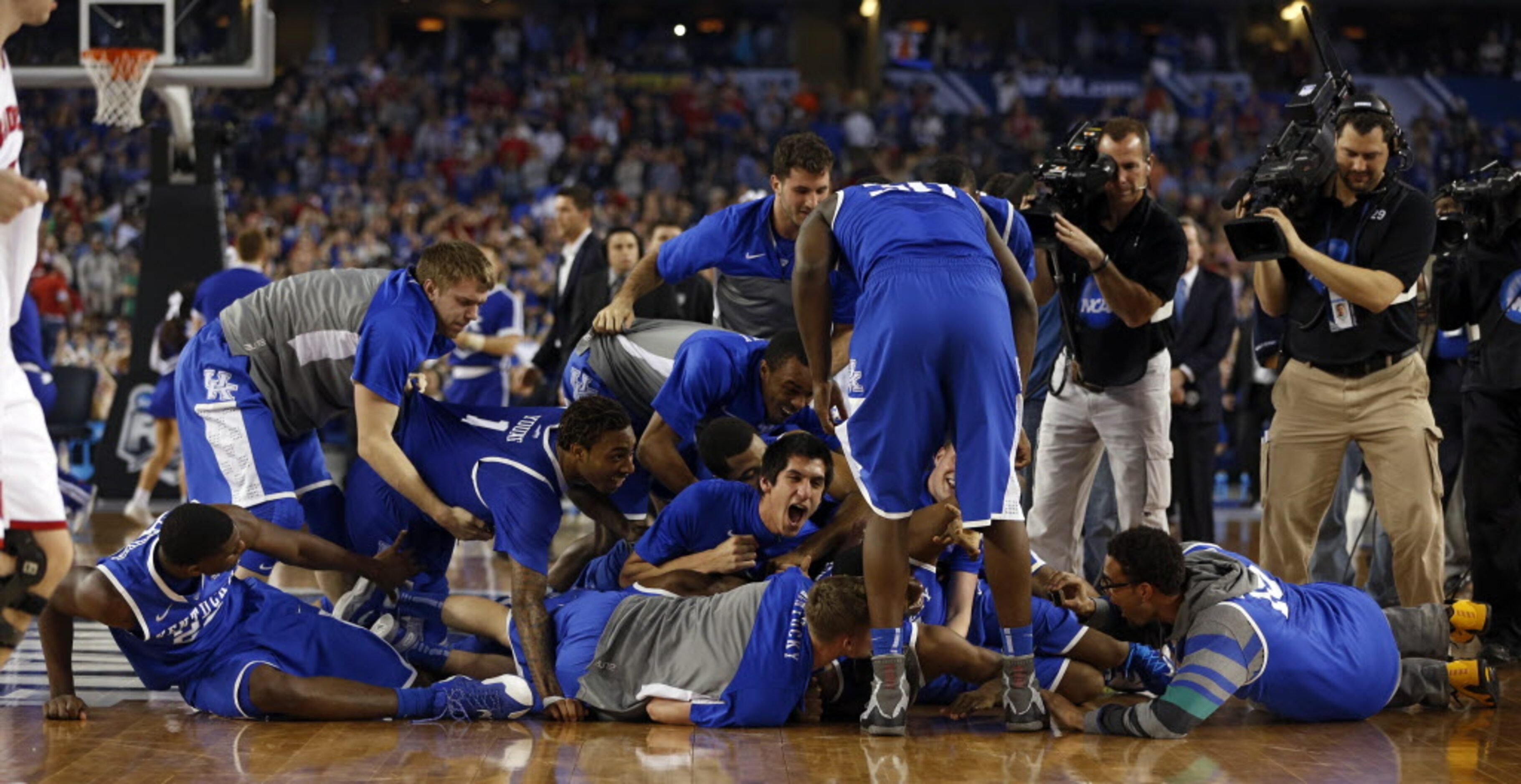 Kentucky Wildcats dog piles Kentucky Wildcats guard Aaron Harrison (2) after defeating the...