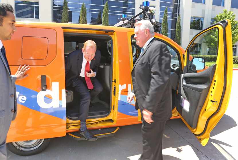 Frisco Mayor Jeff Cheney is greeted by DCTA's Carter Wilson as he emerges from the back seat...
