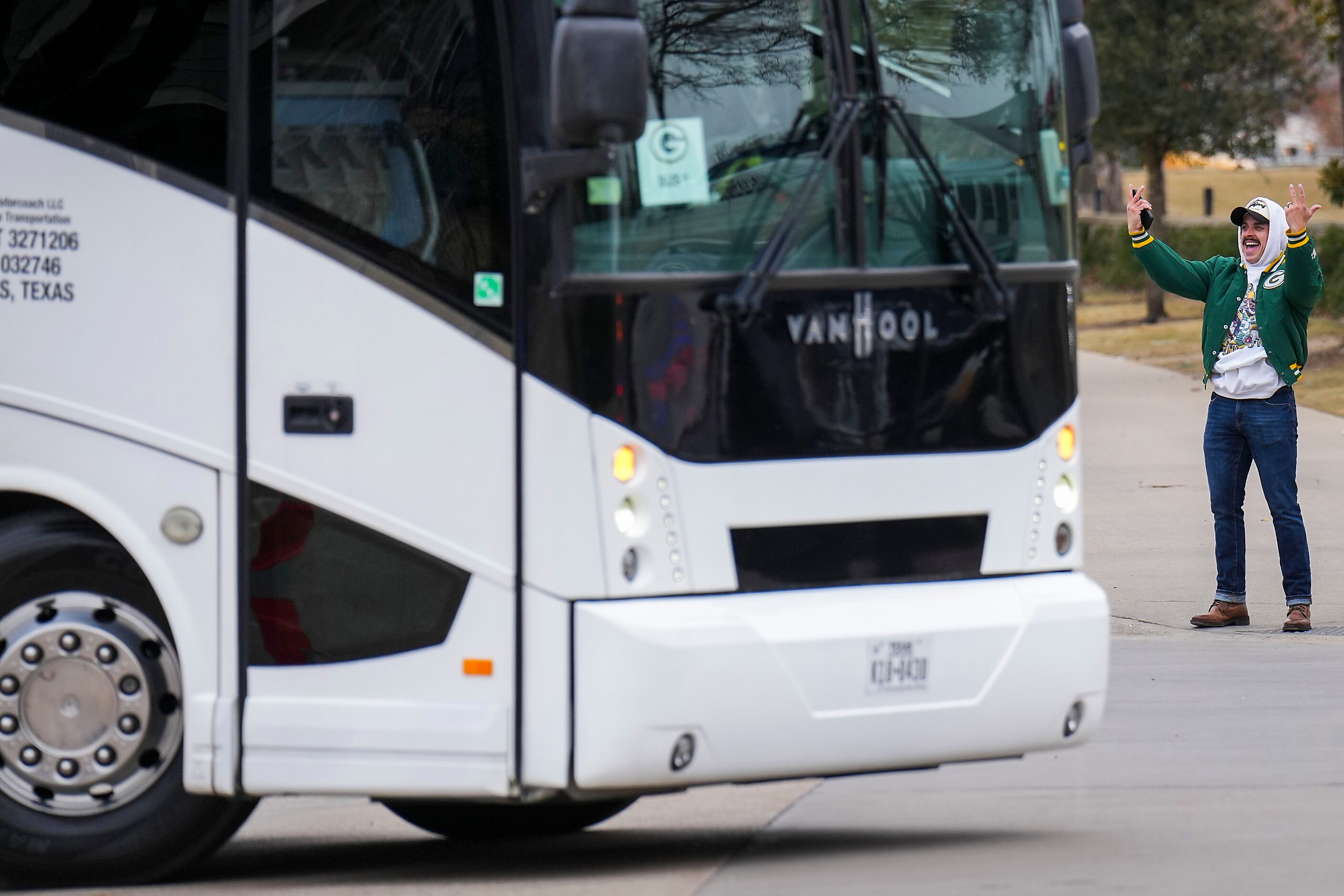 A Green Bay Packers fan cheers as the team buses arrive before an NFL wild-card playoff...