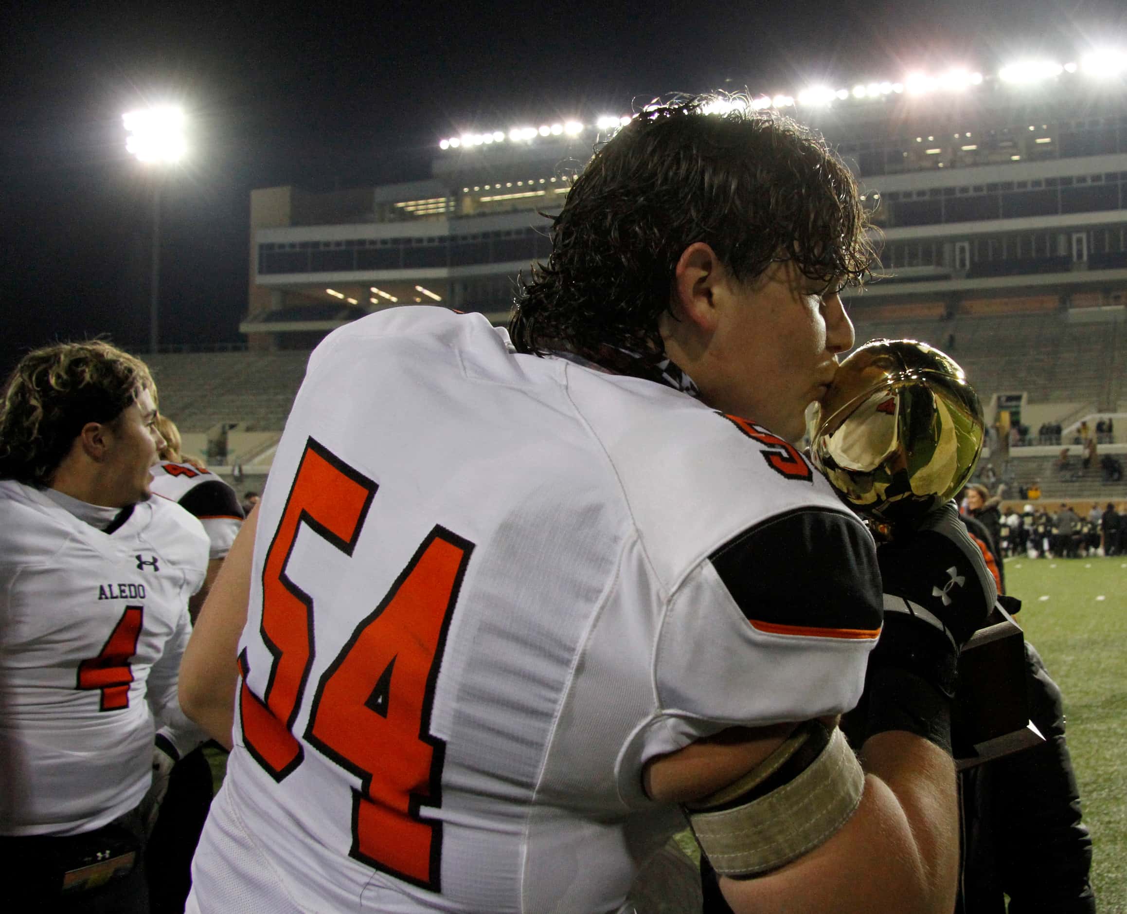 Aledo offensive lineman Rocco O'Keefe (54) leans to kiss the Class 5A Division ll semifinal...