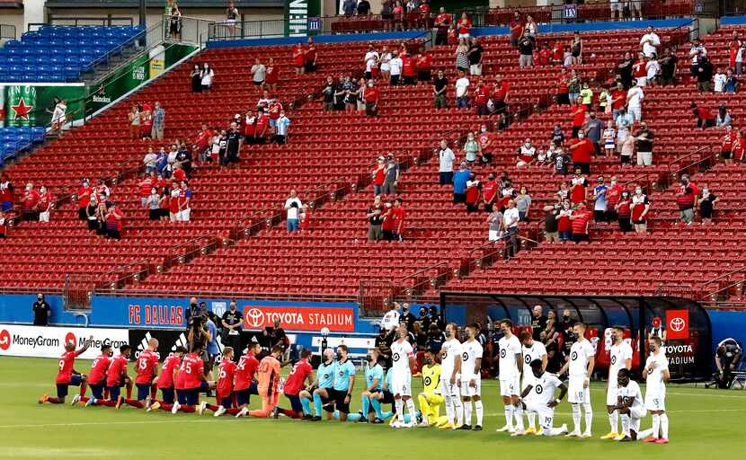 FC Dallas and Minnesota United players take their stance during the national anthem as FC...