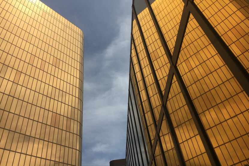 The golden facades of the Campbell Centre, the landmark glowing ingots, reflected in...