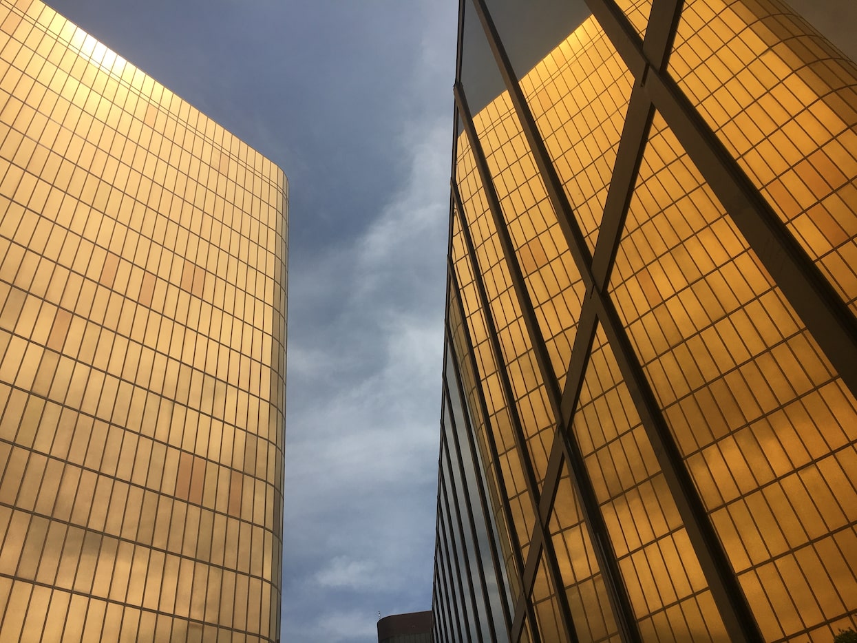 The golden facades of the Campbell Centre, the landmark glowing ingots, reflected in...