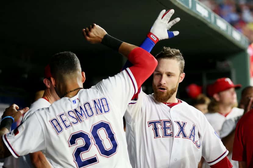 Texas Rangers catcher Jonathan Lucroy (25) celebrates with center fielder Ian Desmond (20)...