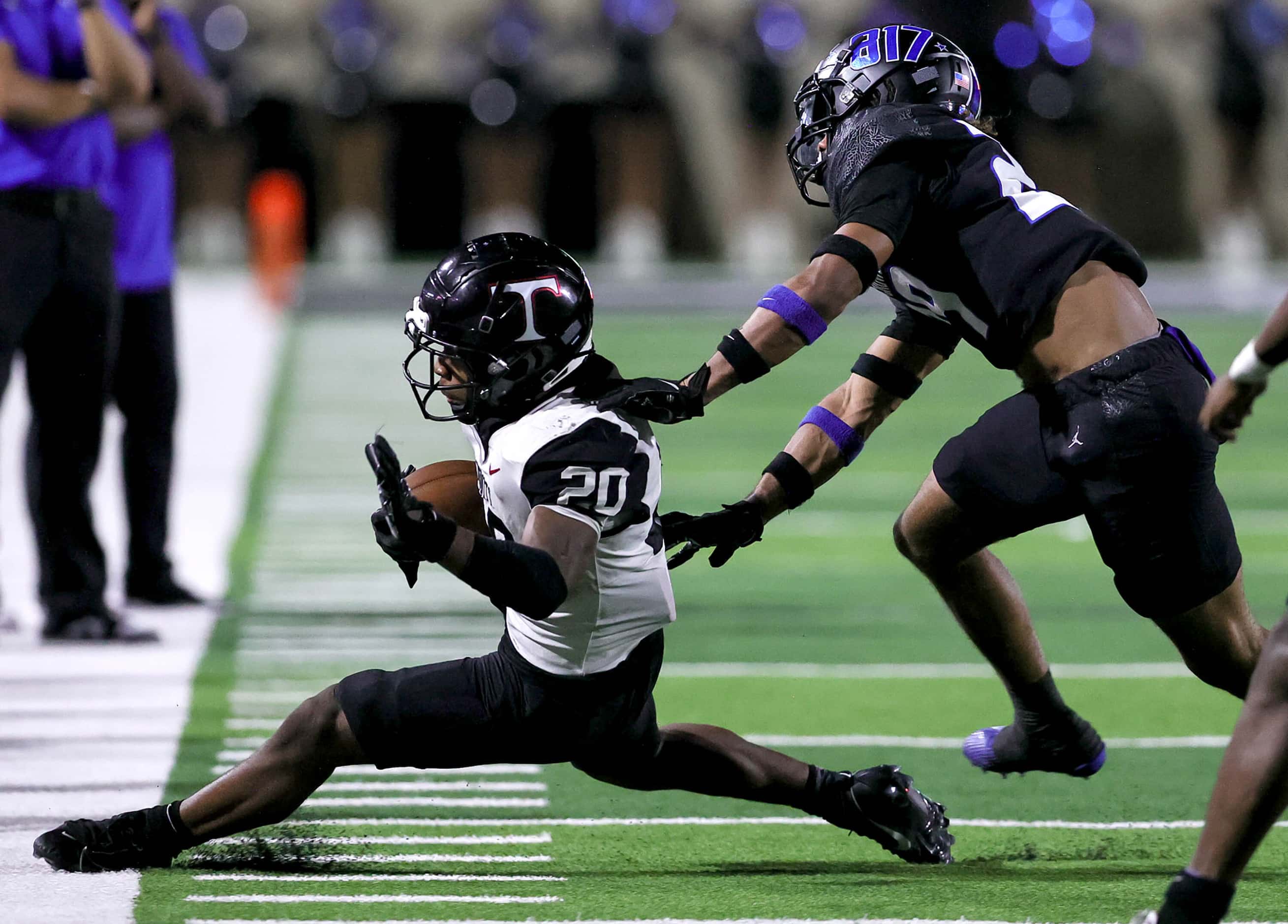 Euless Trinity running back Josh Bell (20) gets pushes out of bounds by North Crowley...