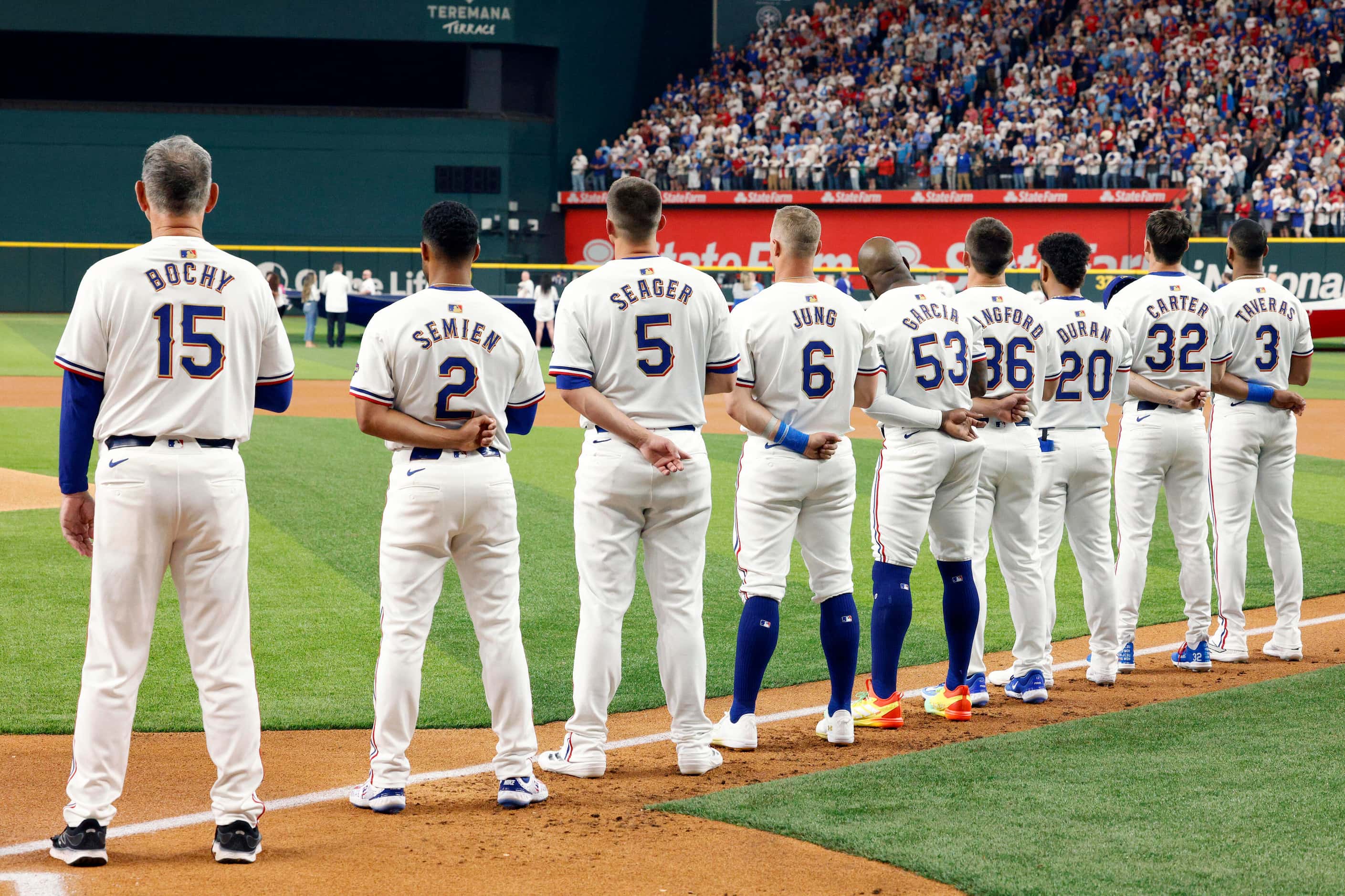 Texas Rangers manager Bruce Bochy stands with the starting lineup for the national anthem...