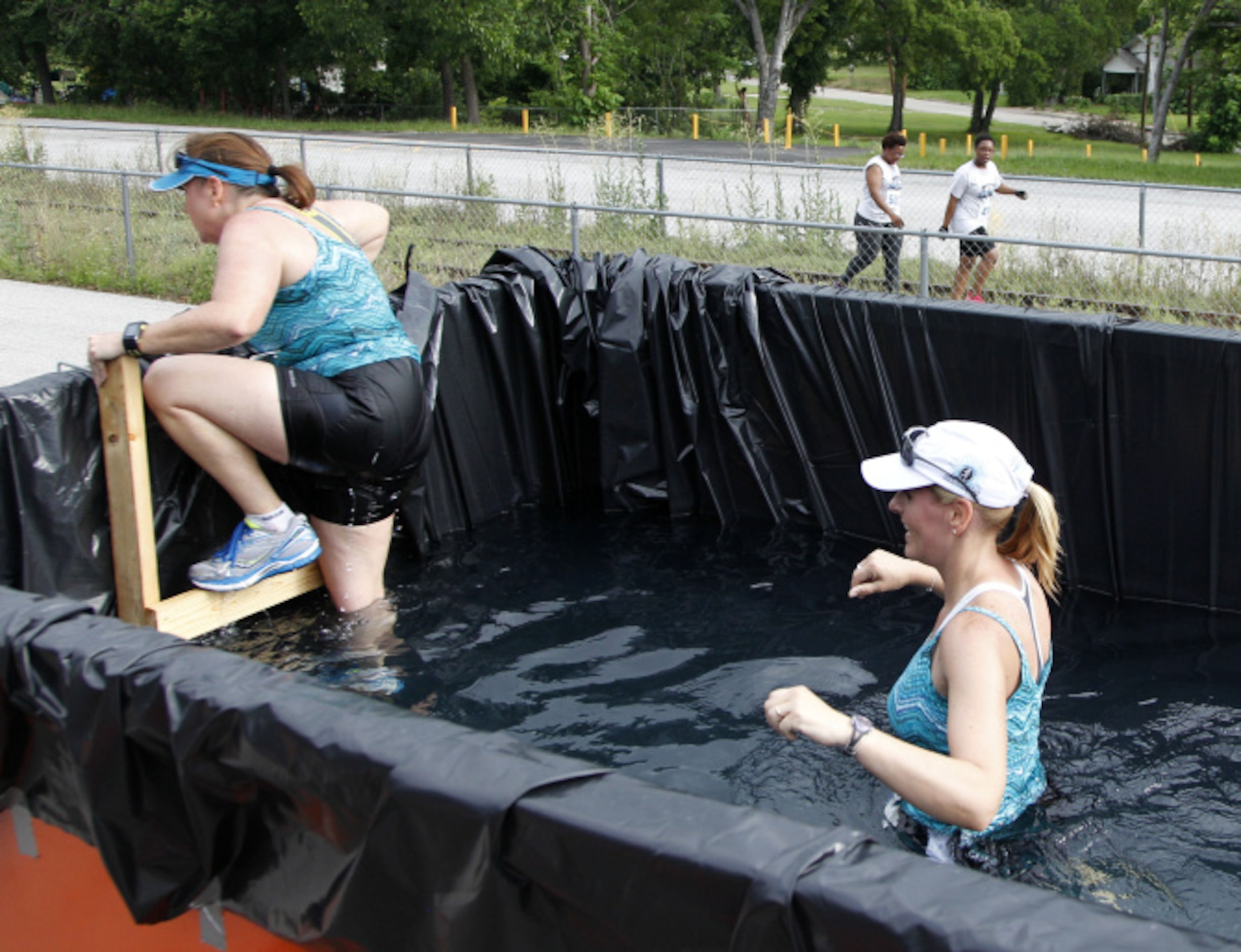 Debbie Sanchez crawls out of a dumpster filled with water as Laurie Buford waits her turn...