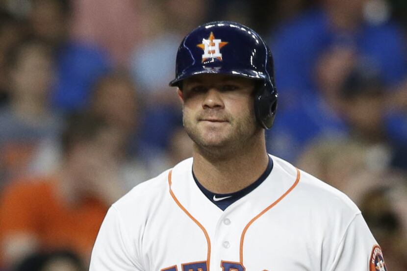 In his first game of the season, Houston Astros' Evan Gattis grimaces after striking out to...