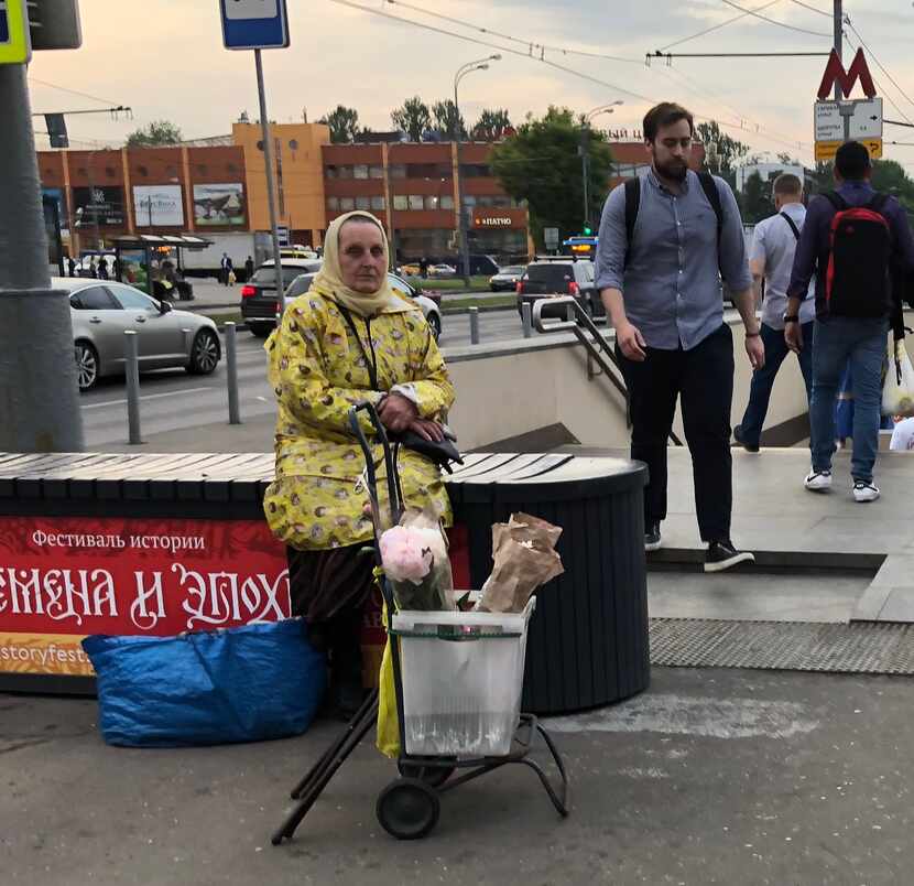 Señora vende flores en la puerta del metro de Moscú.