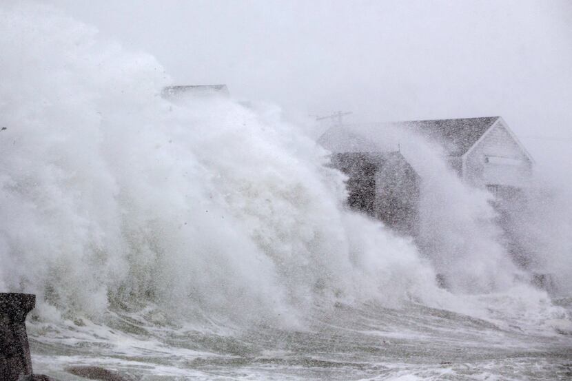 SCITUATE, MA: A wave crashes over a homes on Lighthouse Rd. as a massive winter storm begins...