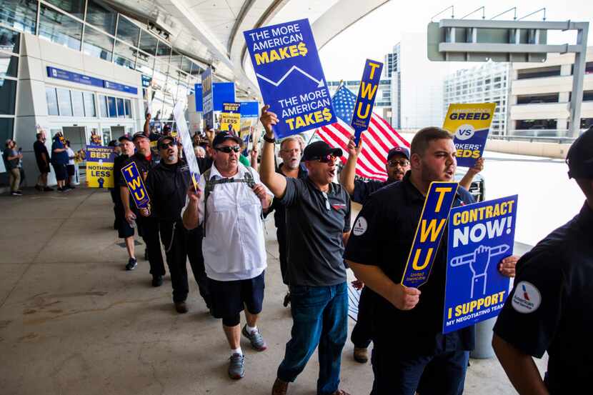 American Airlines employees protested the lack of a new contract for baggage carriers,...