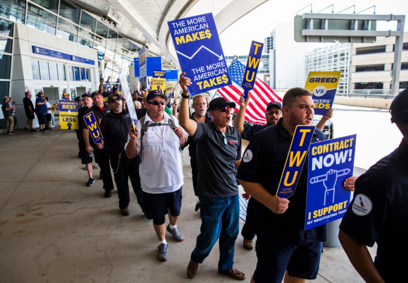 American Airlines employees protested the lack of a new contract for baggage carriers,...