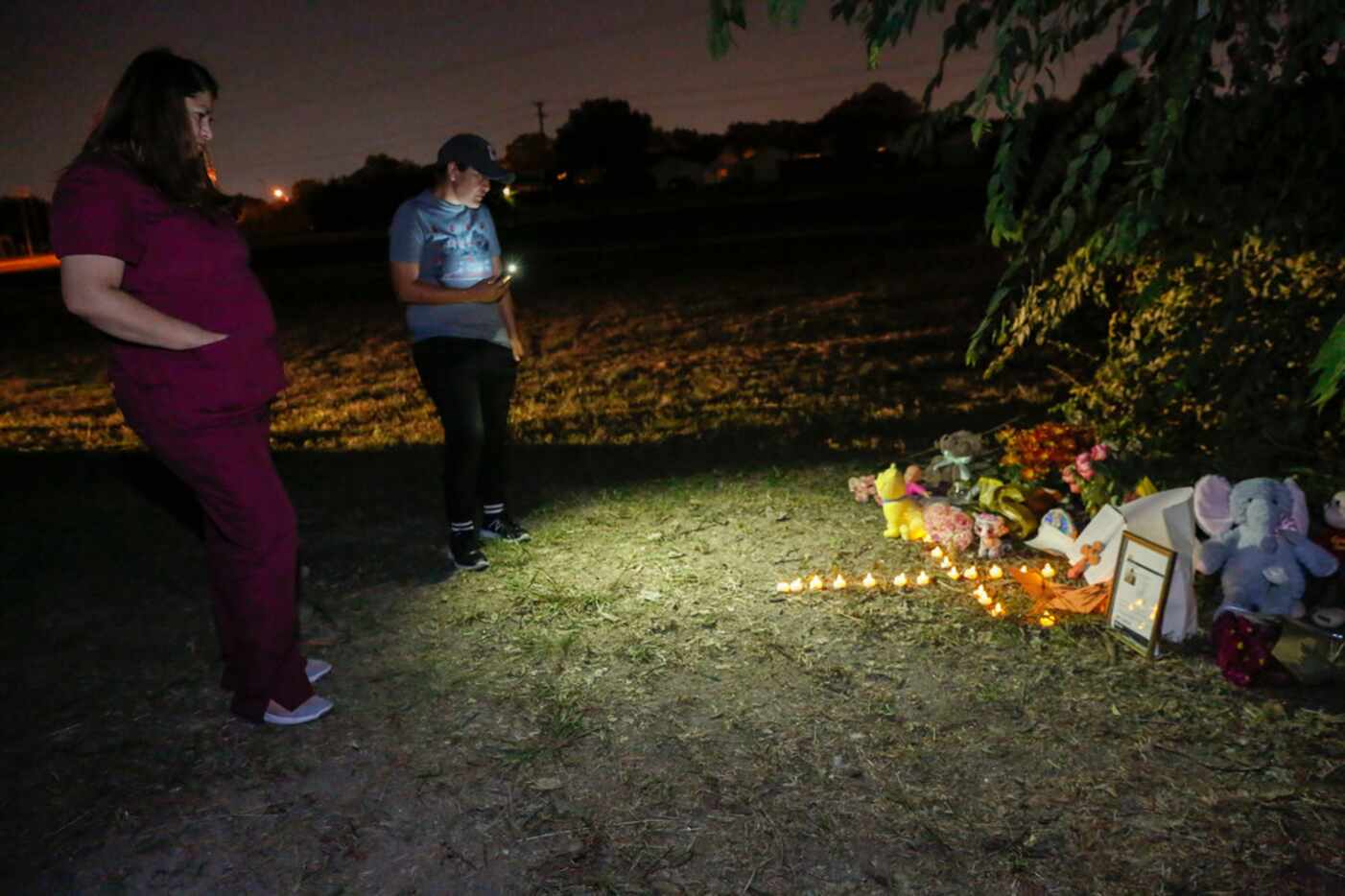 Jasmin Garrido, left, and Noelia Contrera look at a small tribute set up for Sherin Mathews...