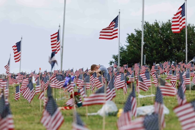 A man paused at a grave after Memorial Day ceremonies at Dallas-Fort Worth National Cemetery...
